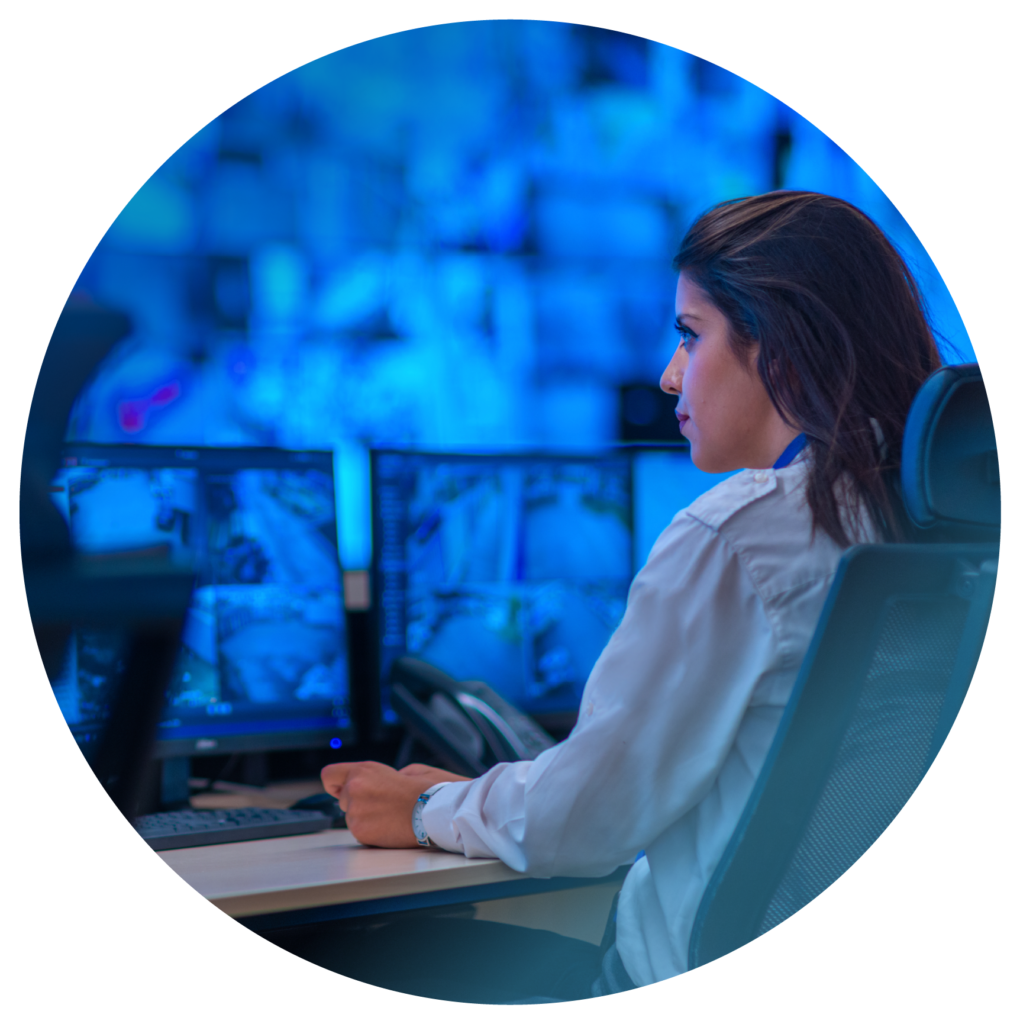 A photo of a women in front of computer screens at work.